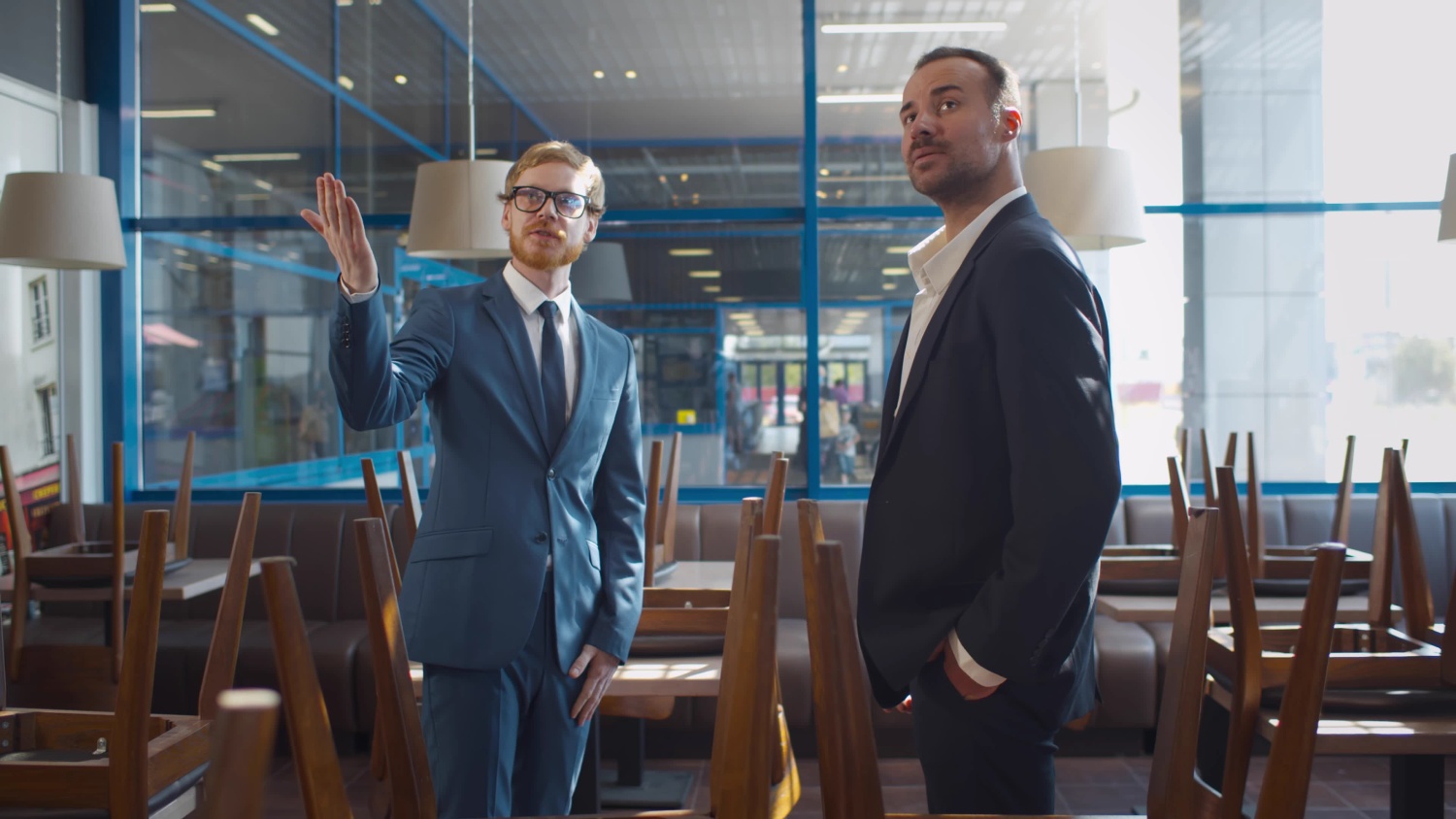 Small businessman renting or buying space for coffee shop or restaurant. Real estate agent and entrepreneur in commercial property shaking hands after successful deal