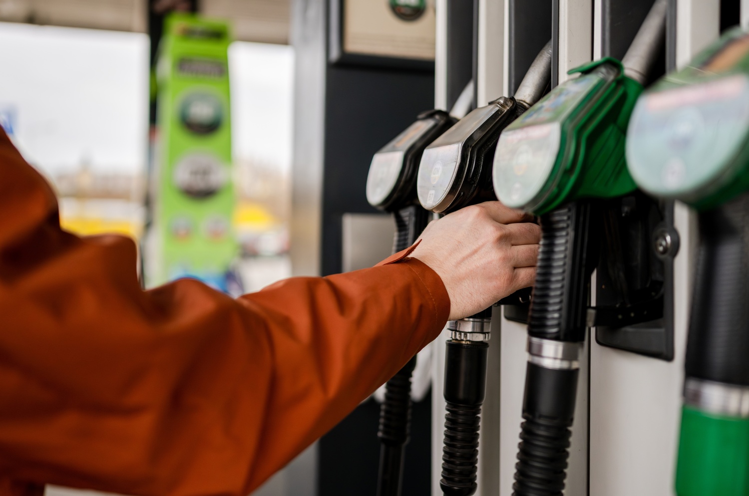 Man Grabbing A Fuel Pump At A Gas Station Refueling A Car
