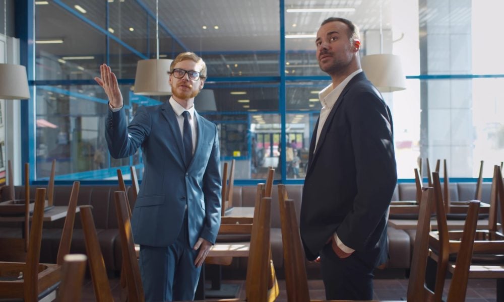 Small businessman renting or buying space for coffee shop or restaurant. Real estate agent and entrepreneur in commercial property shaking hands after successful deal