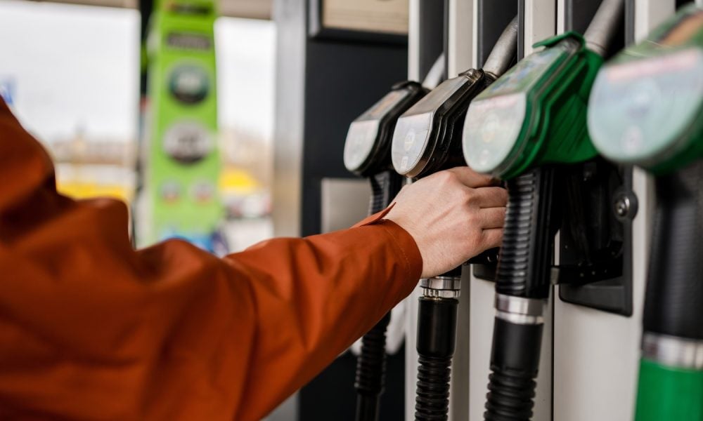 Man Grabbing A Fuel Pump At A Gas Station Refueling A Car
